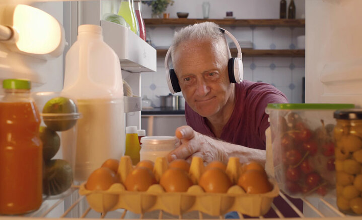 ShutterStock.-Nutrition.-Man-Wearing-Headphones-Looking-In-The-Fridge